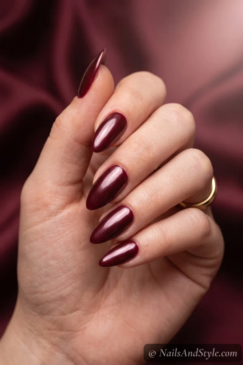 Deep oxblood almond nails with a pearly glazed sheen