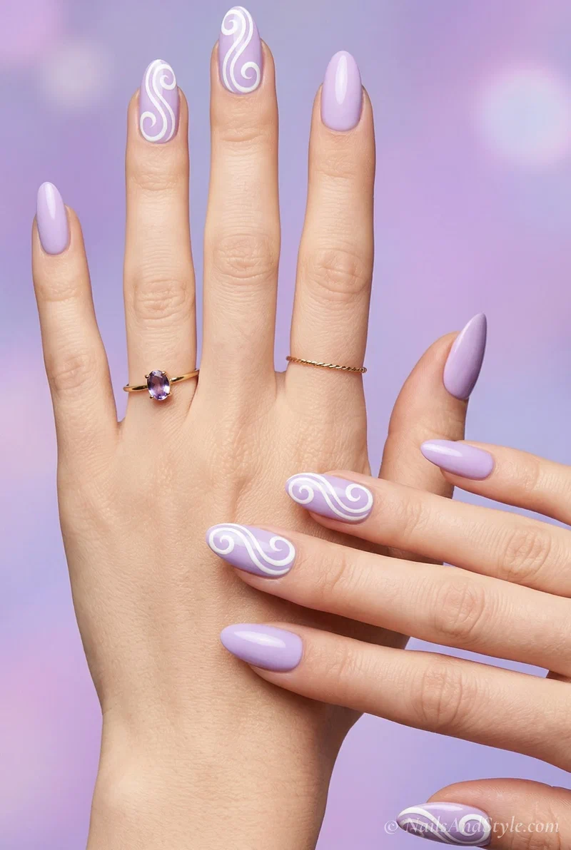 Lavender nails with white swirl accents on almond shaped nails