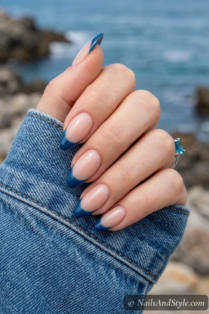 Nude base nails with deep ocean blue French tip design