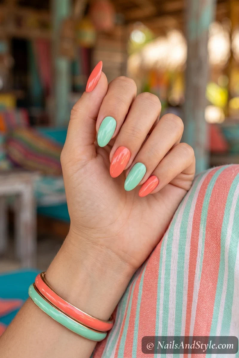 Alternating coral and mint green solid color nails