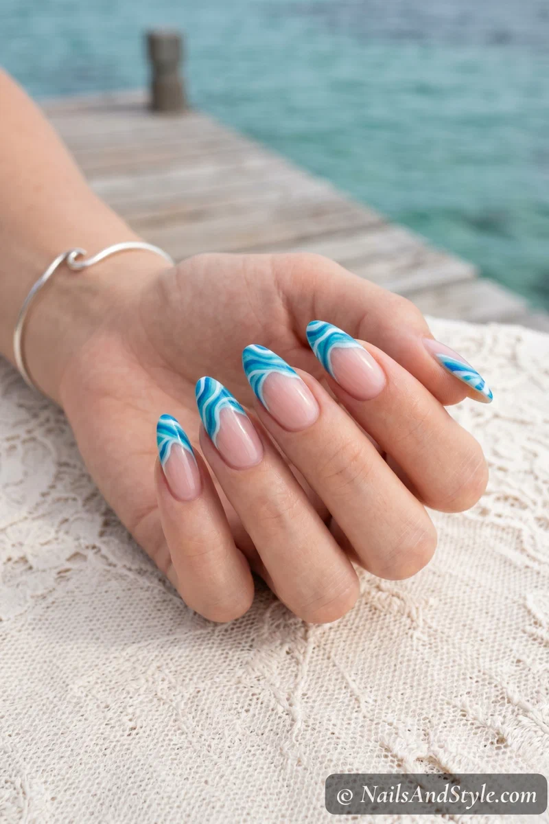 Clear base nails with wavy blue ocean wave French tip design