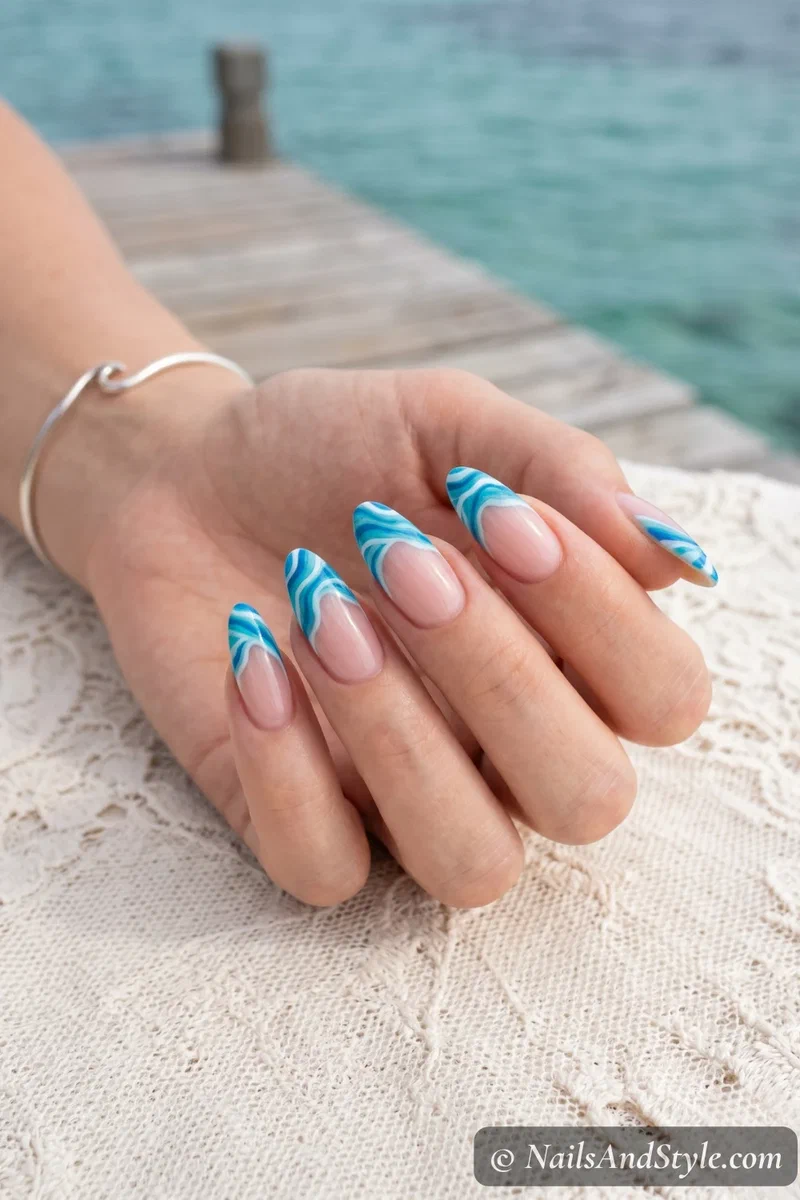 Clear base nails with wavy blue ocean wave French tip design