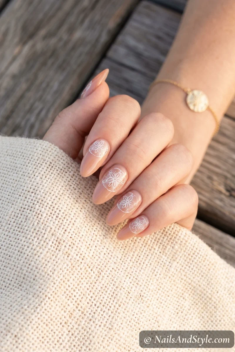 Nude nails with white stamped sand dollar designs