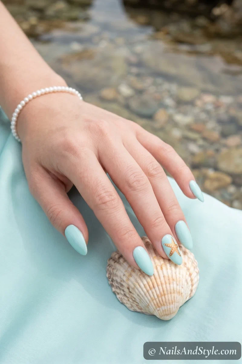 Pale aqua nails with a hand-painted starfish on the accent nail