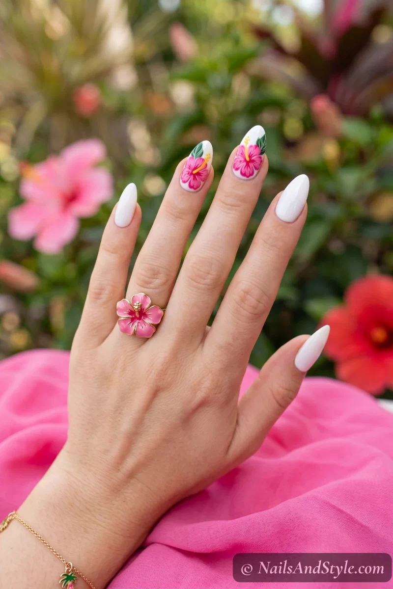 White base nails with bright pink hand-painted hibiscus flower accent