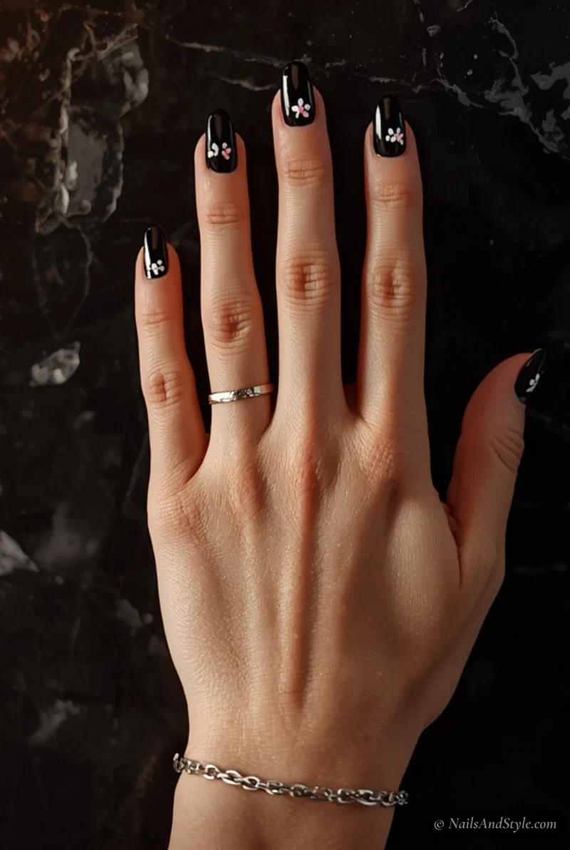 Glossy black nails with tiny white floral stamping for spring