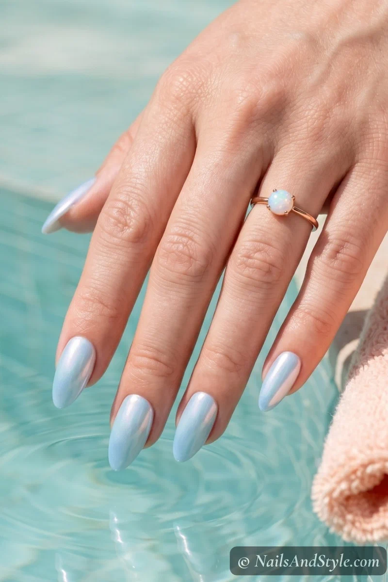 Iridescent blue pearl chrome nails with pearlescent finish on medium almond nails