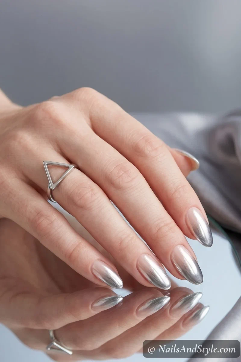 Chrome ombre fade nails with silver gradient fading from tips on medium almond nails