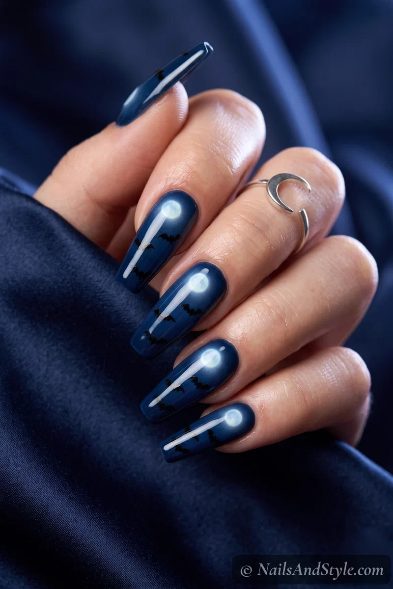 Long coffin nails with a glowing full moon and black bats on a midnight sky