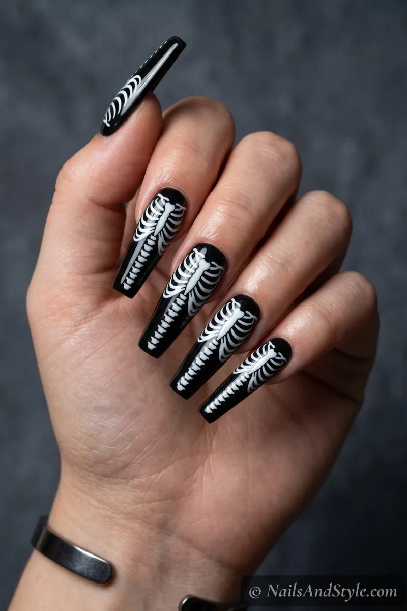 Long black coffin nails with a white ribcage and spine