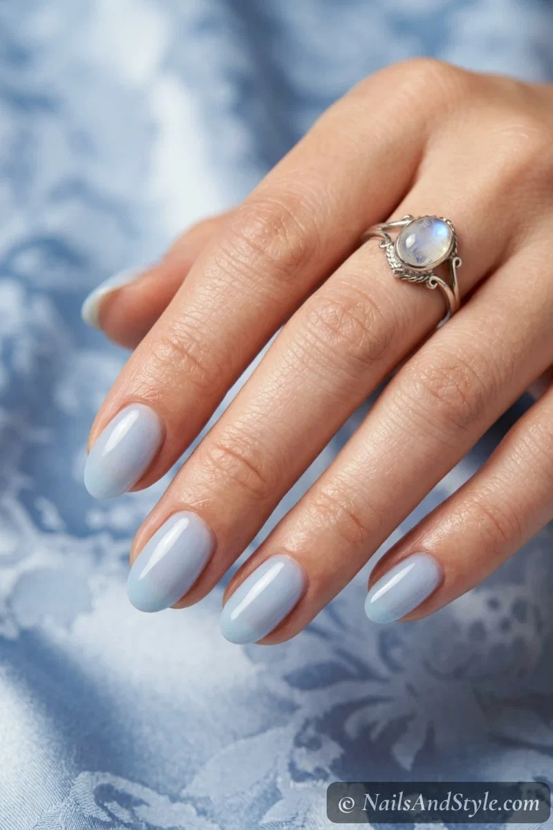 Milky blue nails with a soft milky pastel blue and glossy finish on short oval nails