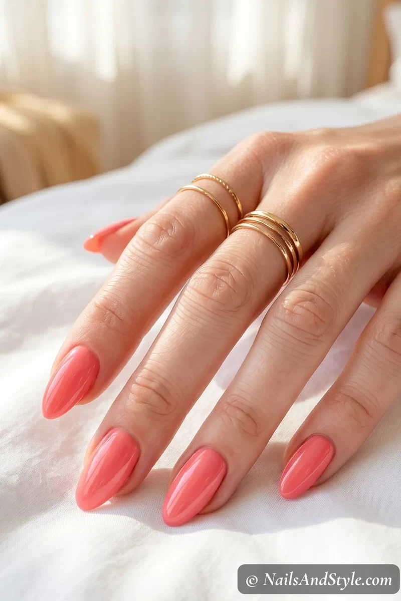 Creamy coral pink glossy nails on medium almond shaped nails