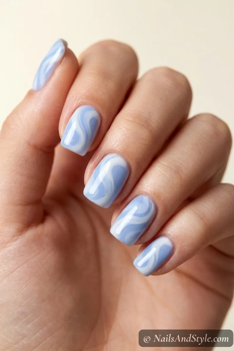 Pale blue and white swirl nails