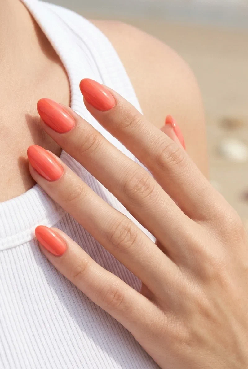 Coral glazed glossy nails on short almond shape with high shine finish