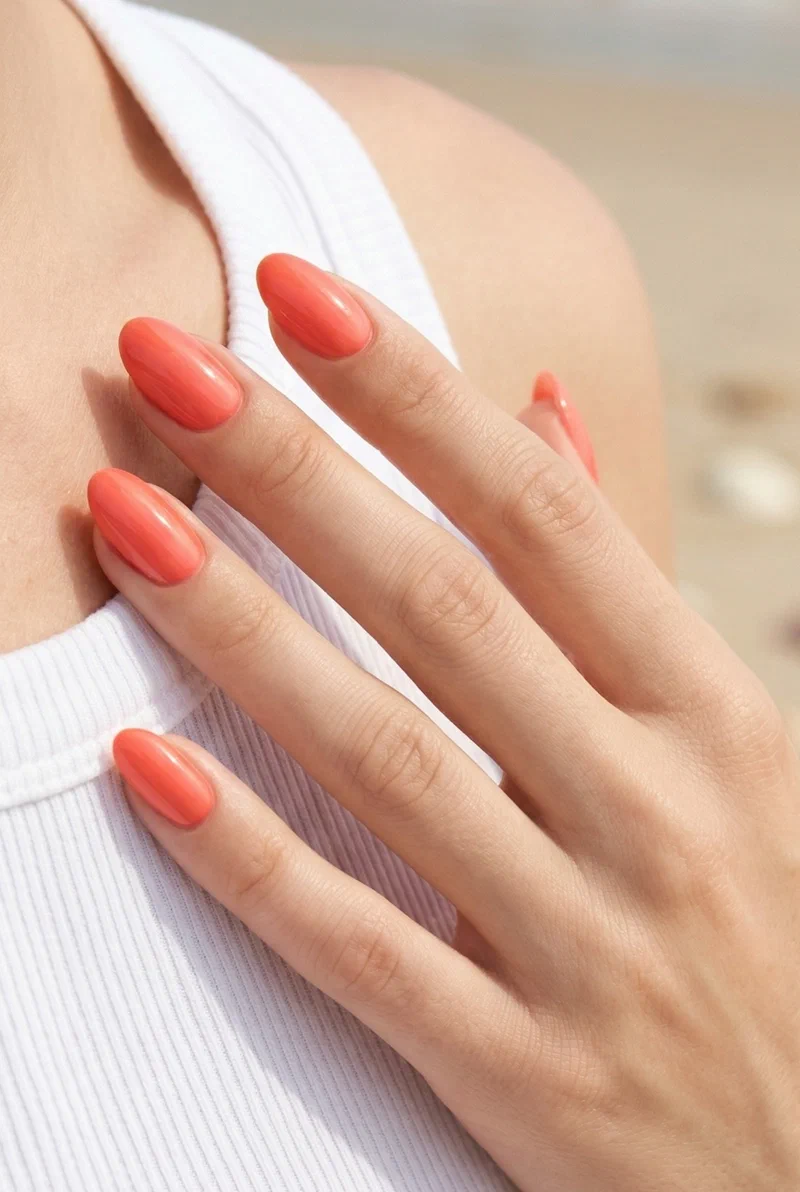 Coral glazed glossy nails on short almond shape with high shine finish