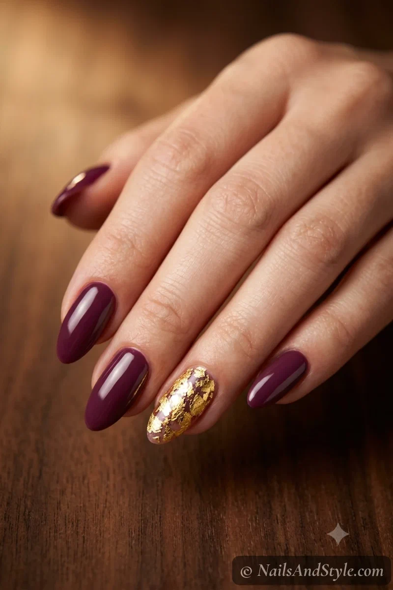 Plum nails with a gold leaf accent nail