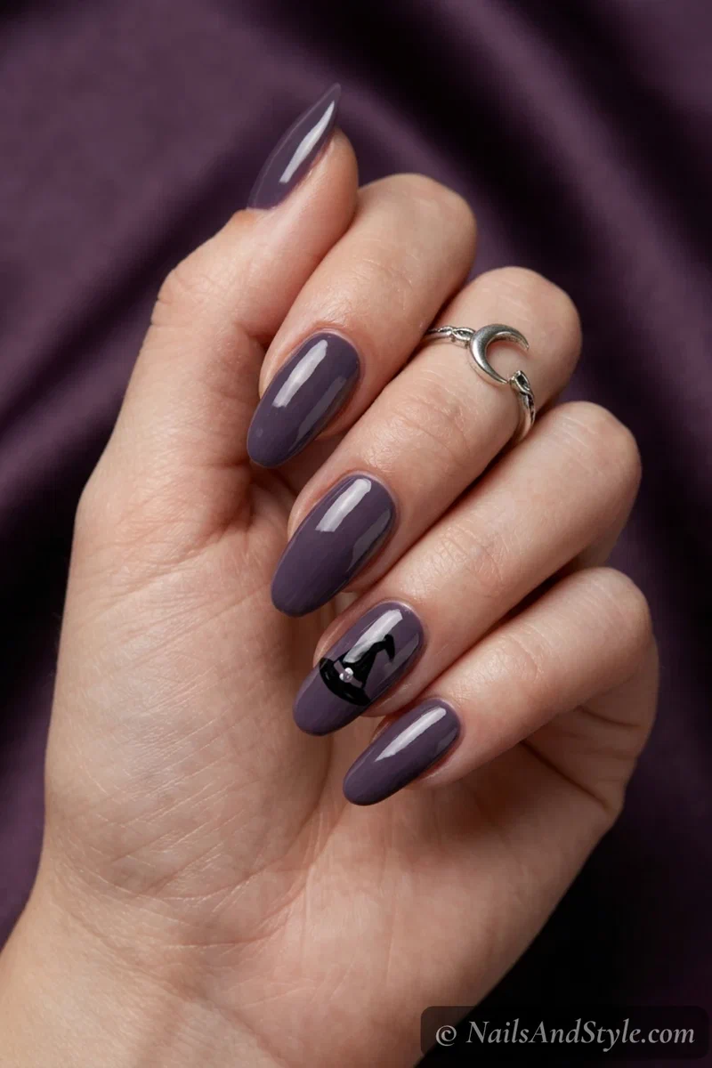 Dusky purple nails with a simple black witch hat on an accent nail