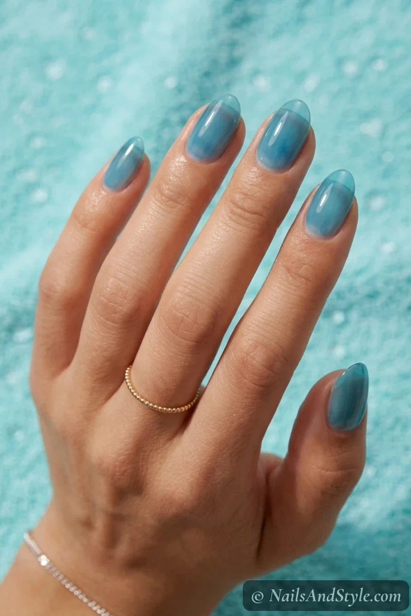 Last swim blue jelly nails with a sheer translucent ocean blue on medium almond nails