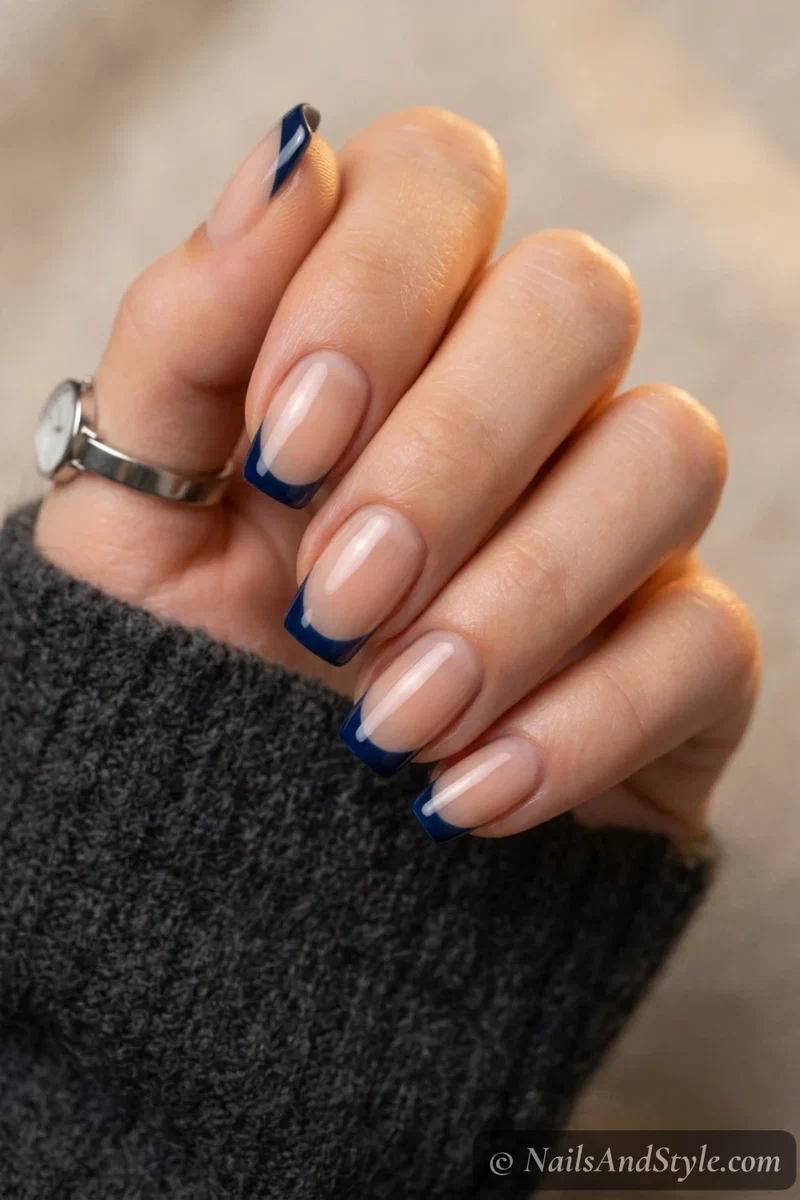 Navy clean French nails with crisp navy tips over a sheer nude base on medium squoval nails