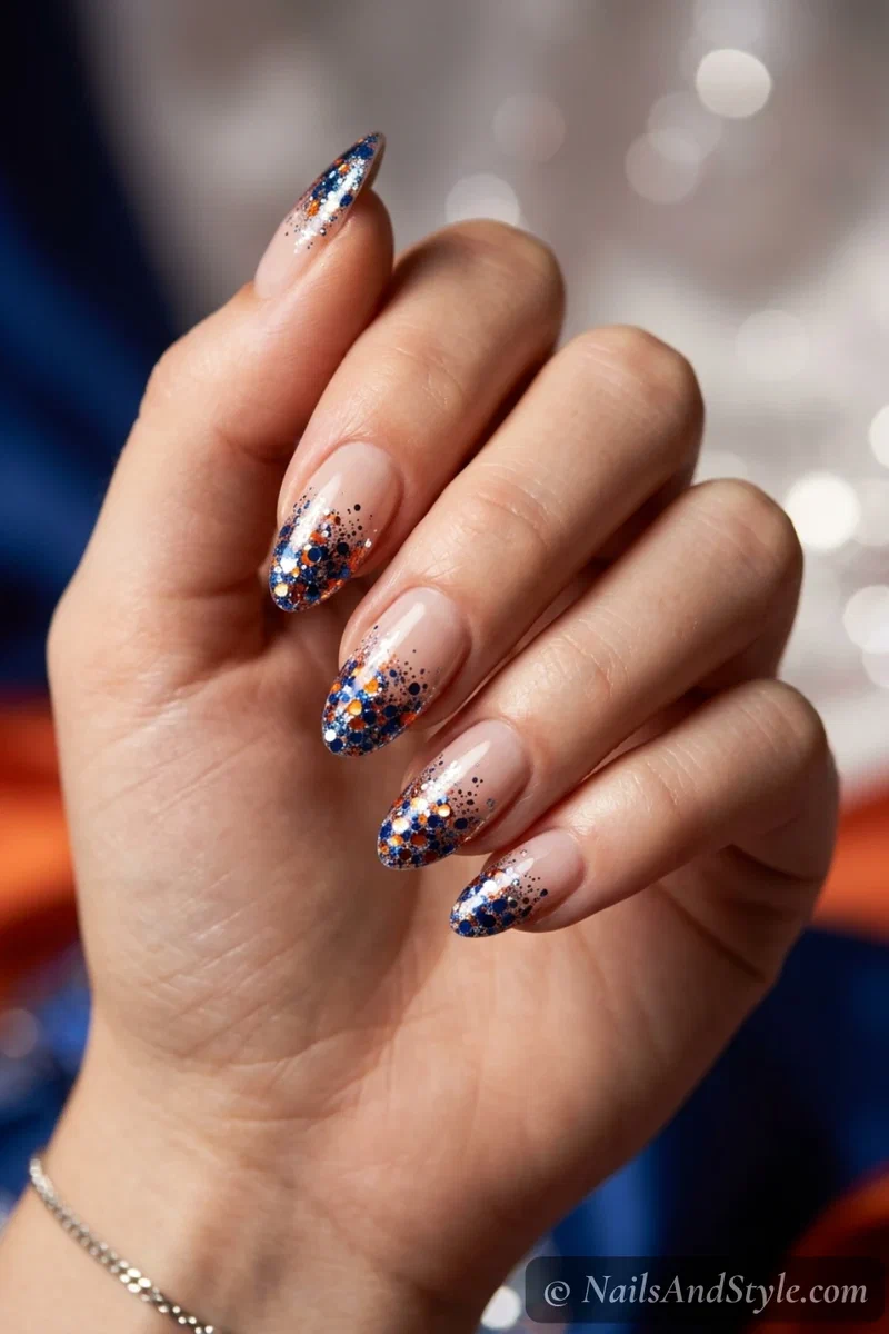 Pom-pom glitter tip nails with chunky team-color glitter fading from the tips over a soft base, medium almond nails