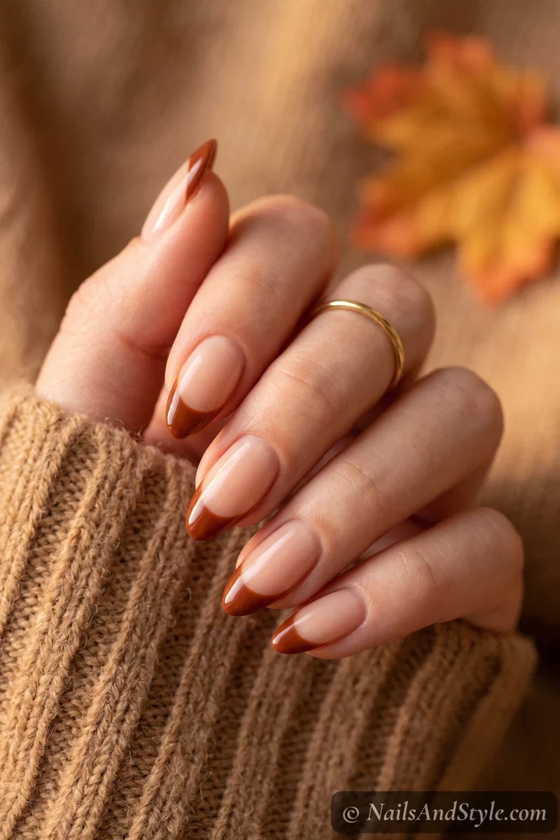 Nude base nails with warm rust-brown French tips for fall