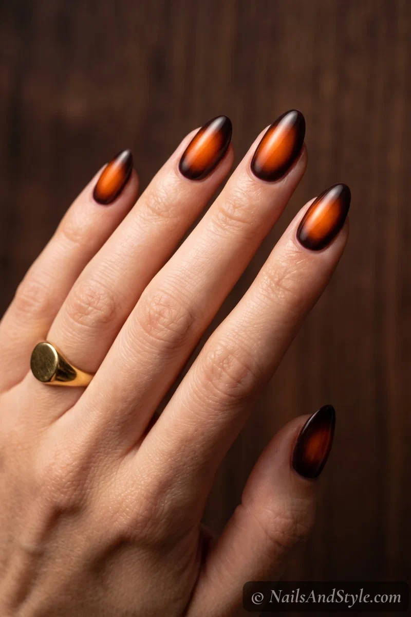 Dark nails with a blurred burnt orange aura glow