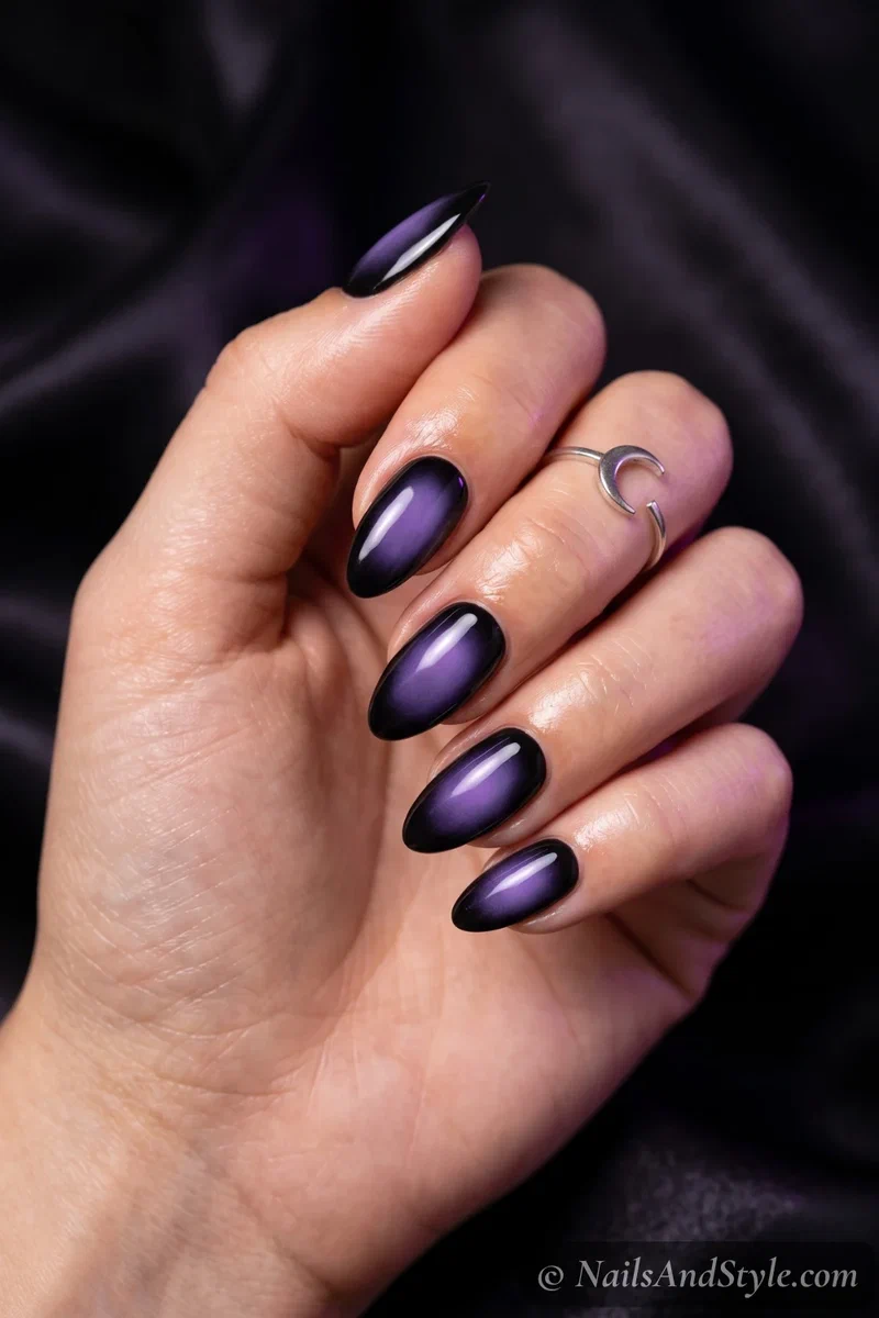 Black nails with a soft blurred purple aura glow in the center