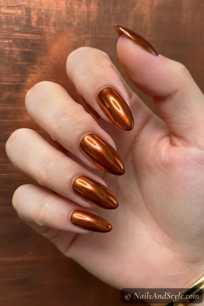 Burnt orange chrome nails with a mirror metallic finish