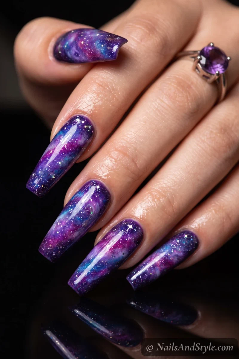 Long nails with a purple, blue, and pink galaxy and star specks