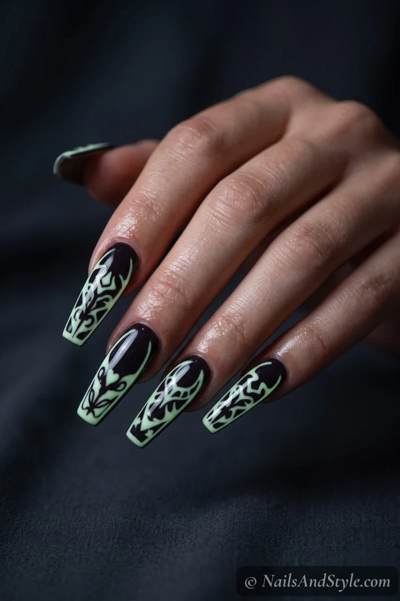 Long dark nails with a design glowing green in low light