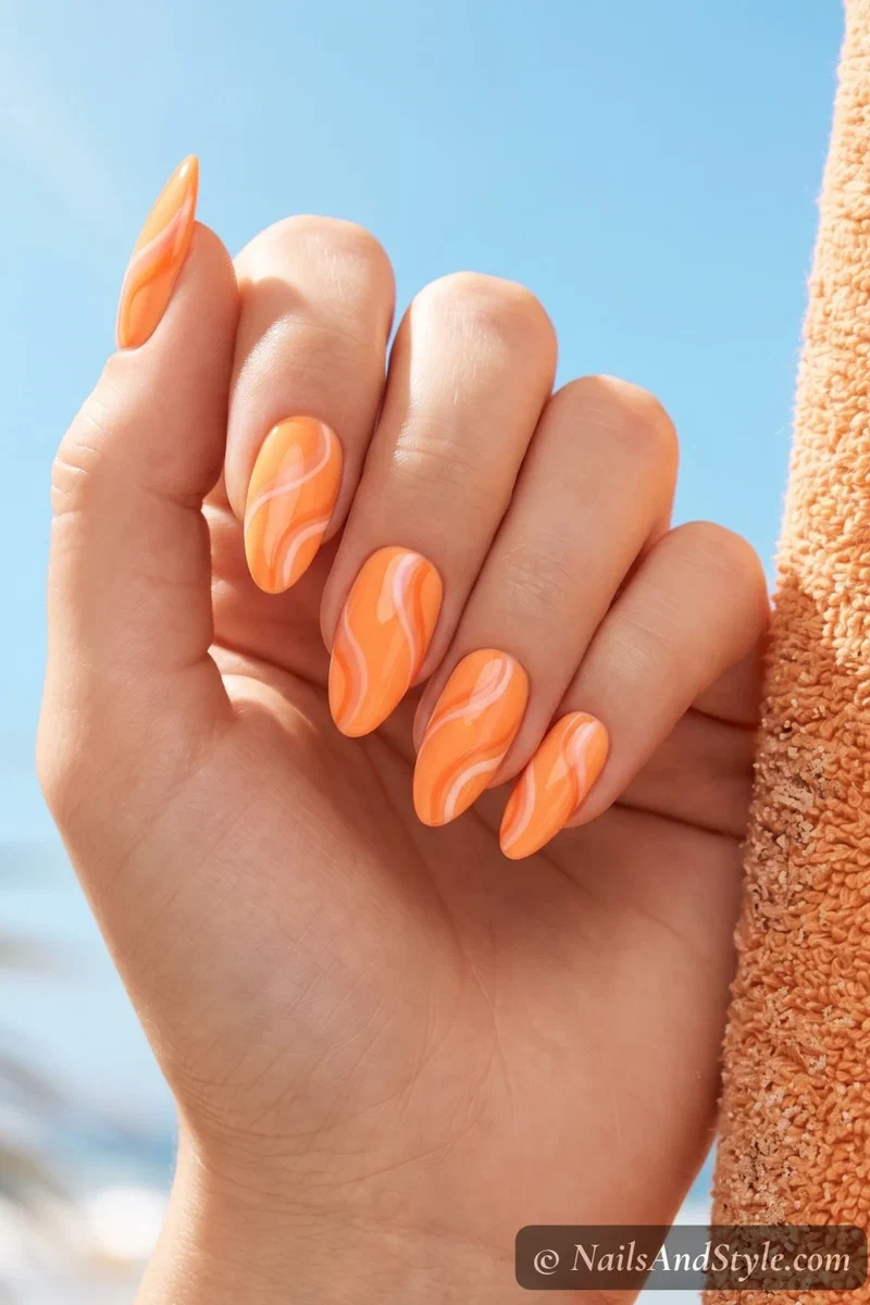 Soft neon tangerine almond acrylic nails with glossy finish