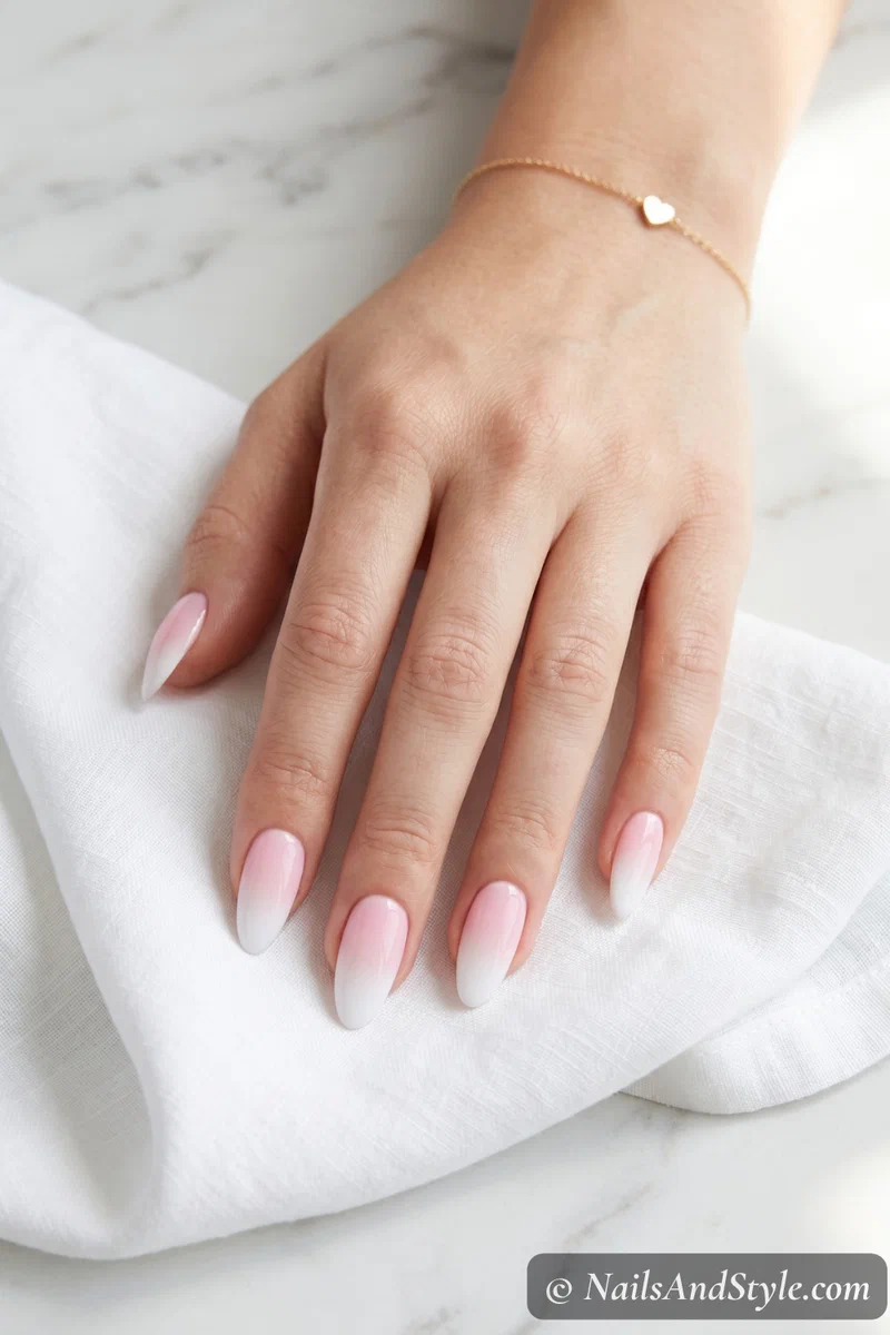 Classic pink to white ombre fade on medium almond nails with glossy finish