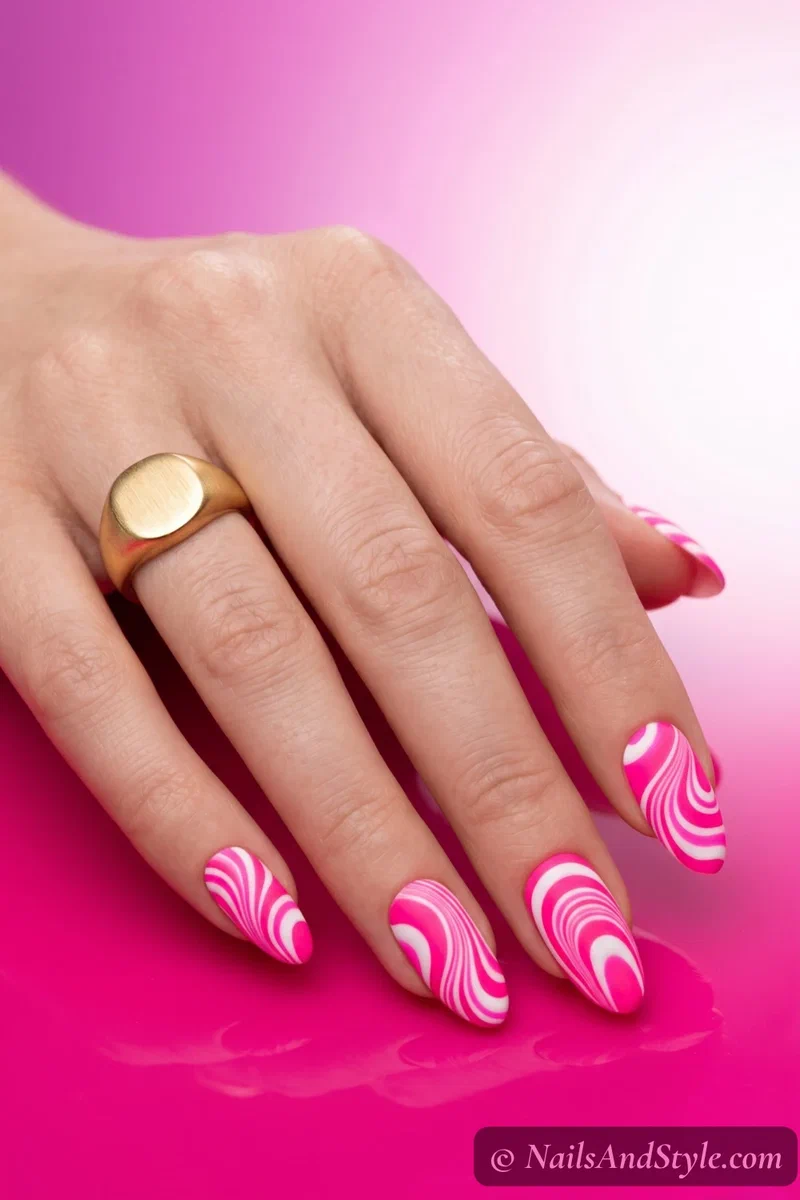Neon pink and white water marble nails with bold graphic swirl lines and matte finish