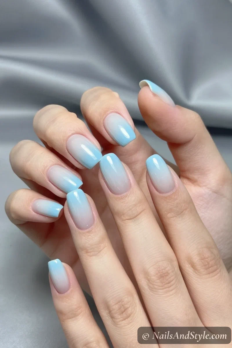 Baby blue chrome ombré nails fading from milky white to metallic blue