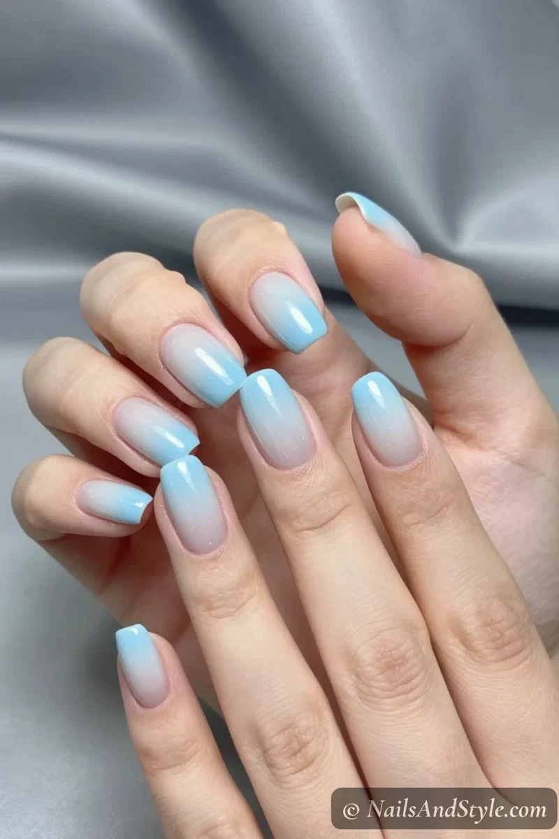 Baby blue chrome ombré nails fading from milky white to metallic blue