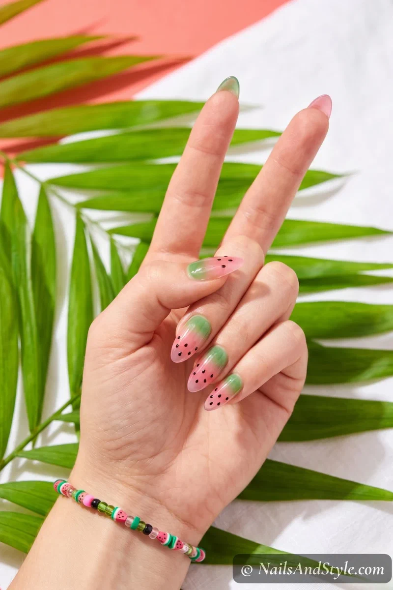 Watermelon jelly nails with green to pink sheer gradient and tiny black seed dots
