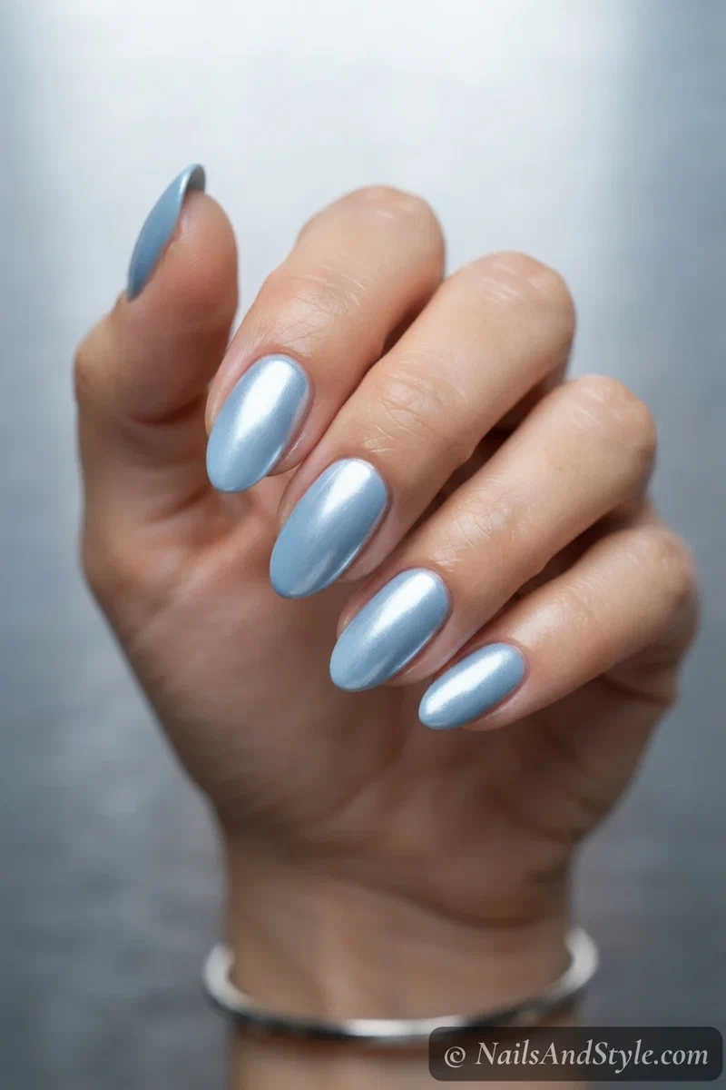 Sky blue chrome nails with a mirror metallic silver-blue finish on medium almond nails
