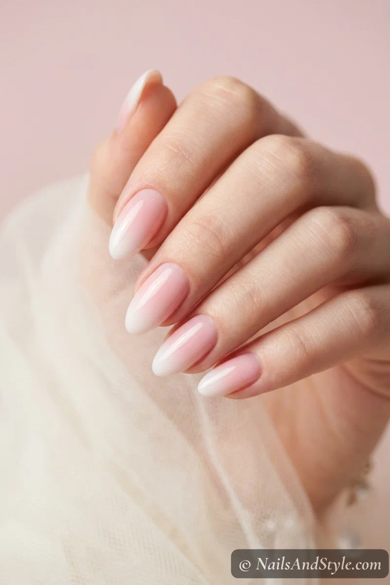 Baby boomer ombre nails with a sheer pink base fading into milky white tips on medium almond nails