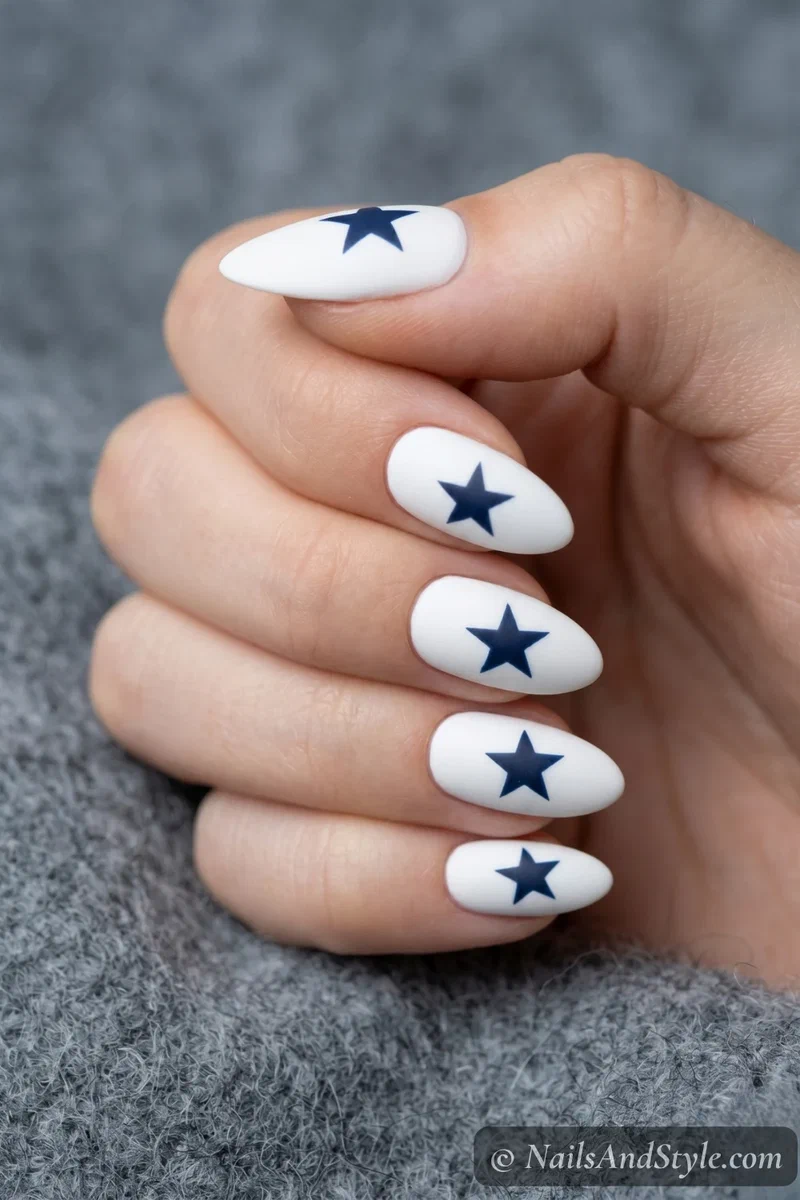 White matte nails with off-center navy blue stars