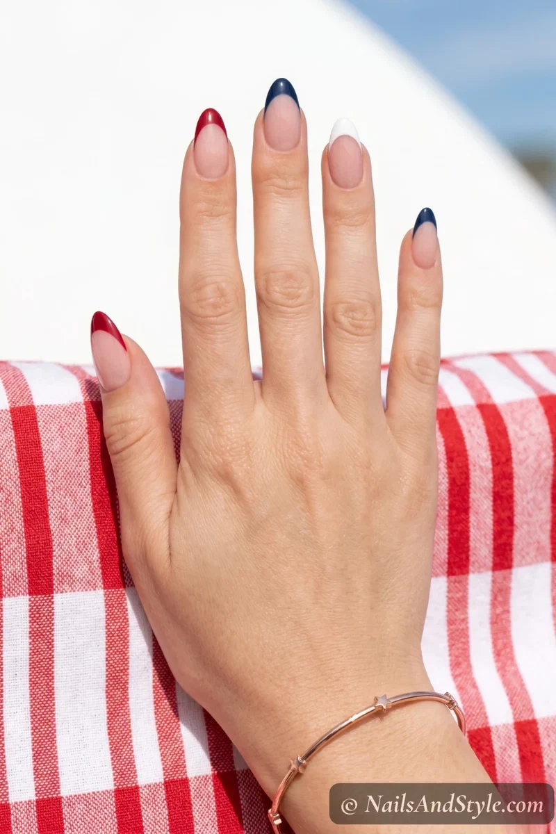 Sheer base nails with alternating red white and navy French tips