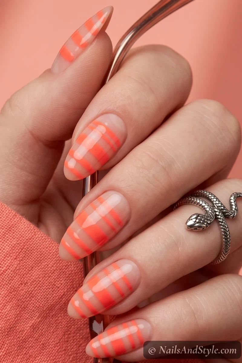 Nude nails with neon coral stripes