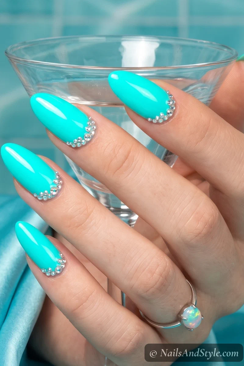 Neon aqua nails with rhinestone cuticle clusters