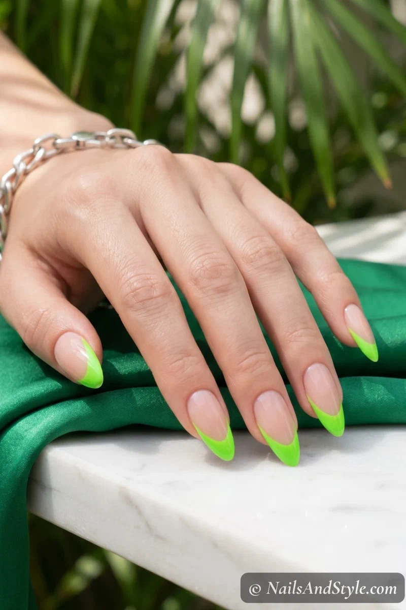 Neon green French tip nails on a nude base