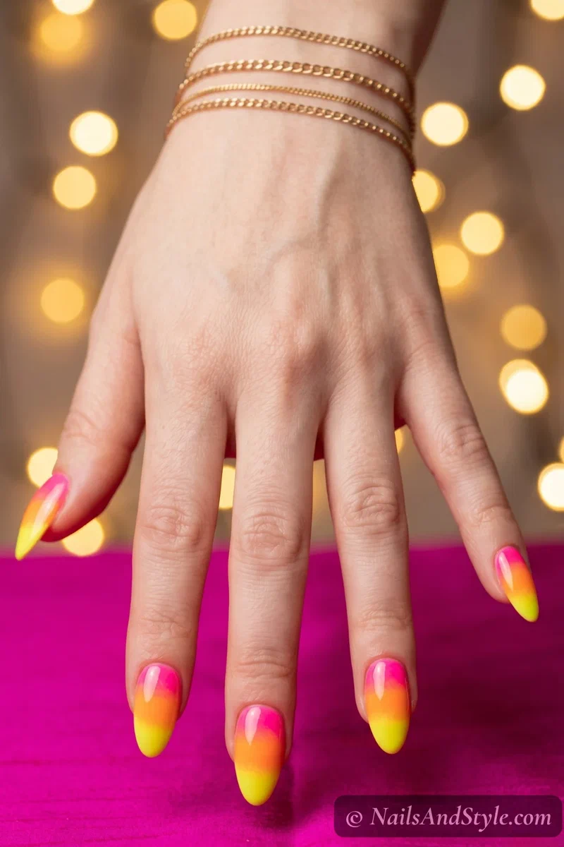 Neon sunset gradient nails blending pink, orange, and yellow