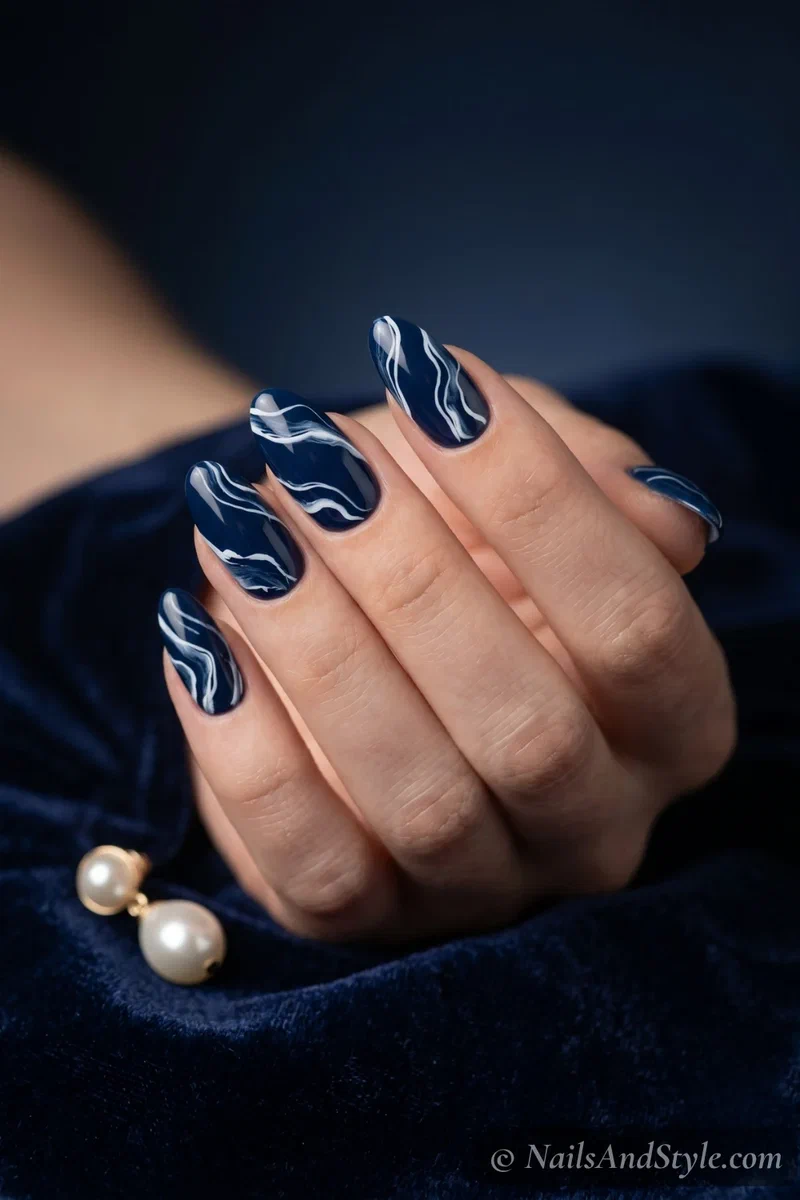 Deep navy nails with white swirl wave pattern