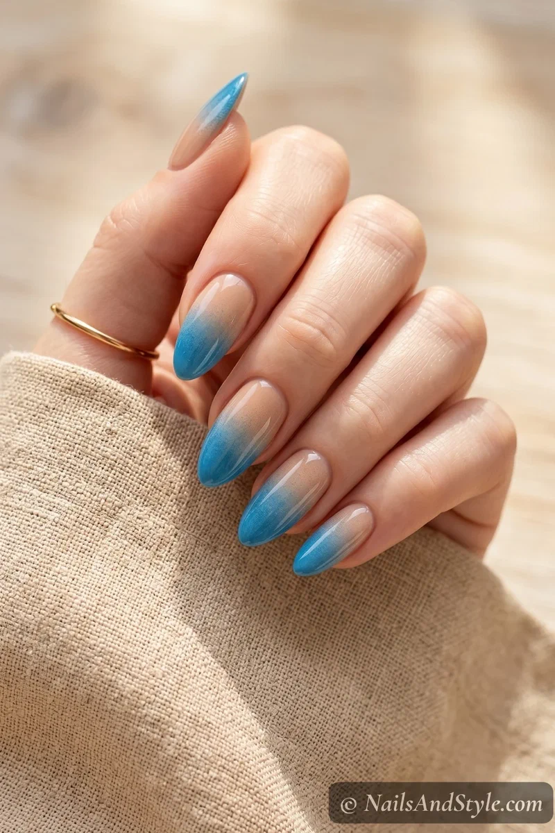Gradient nails fading from sandy nude to ocean blue at the tips