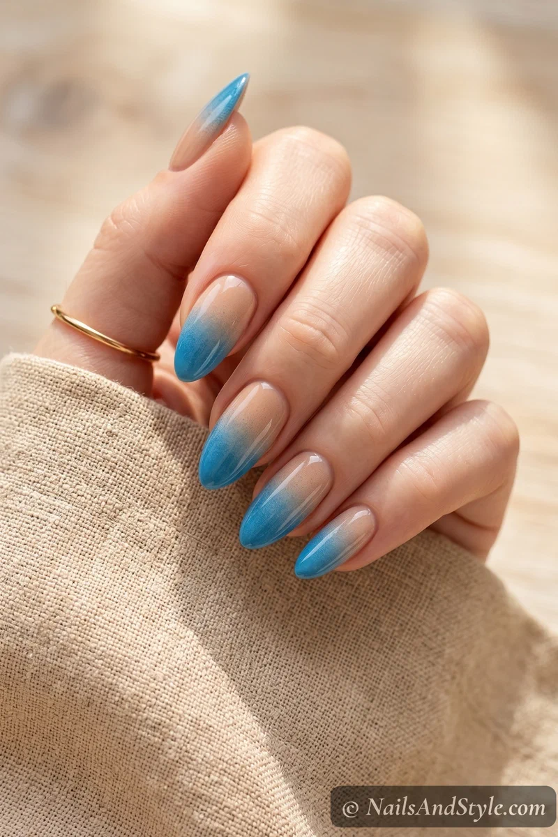 Gradient nails fading from sandy nude to ocean blue at the tips