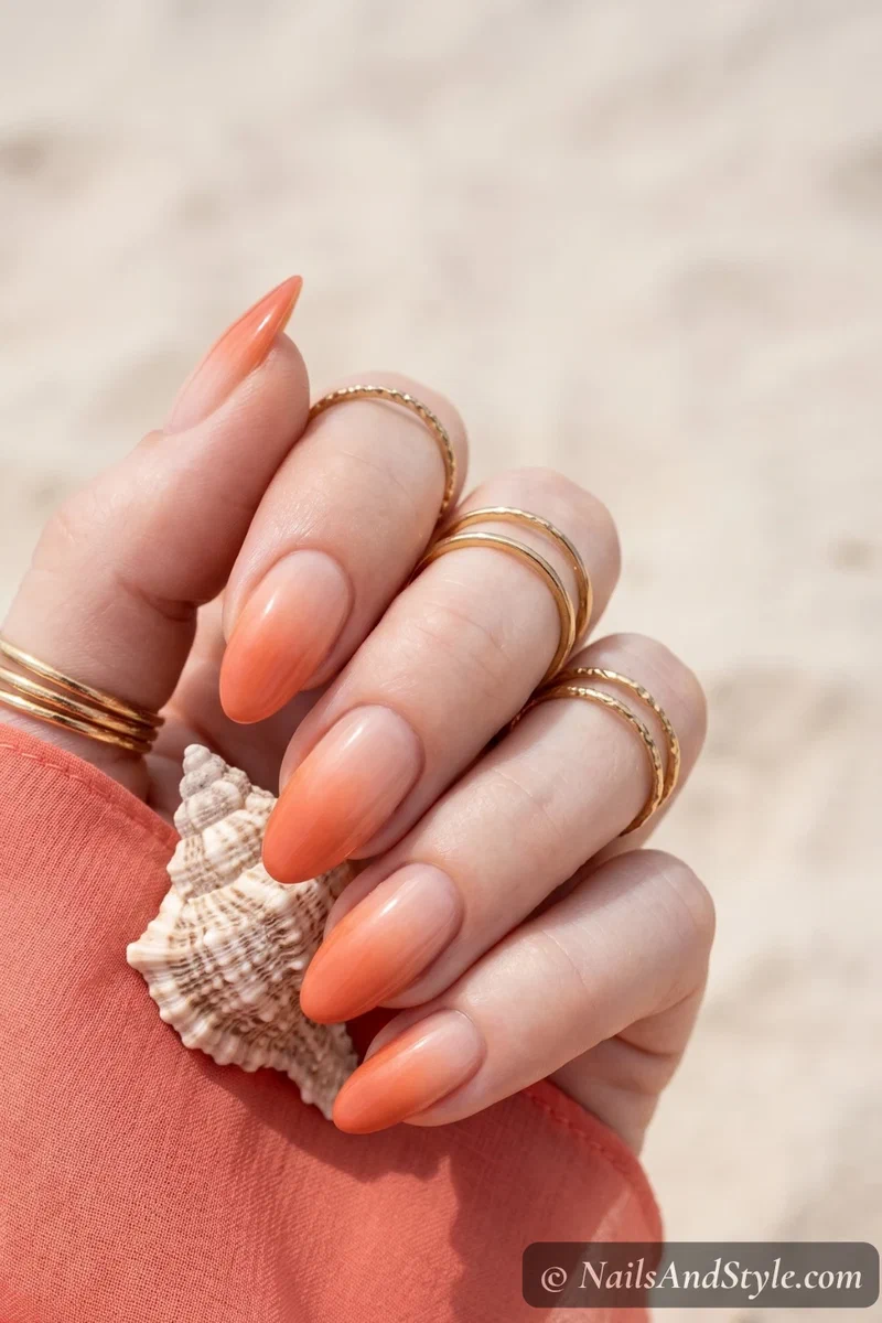 Coral orange ombre gradient nails fading from nude to coral on almond nails