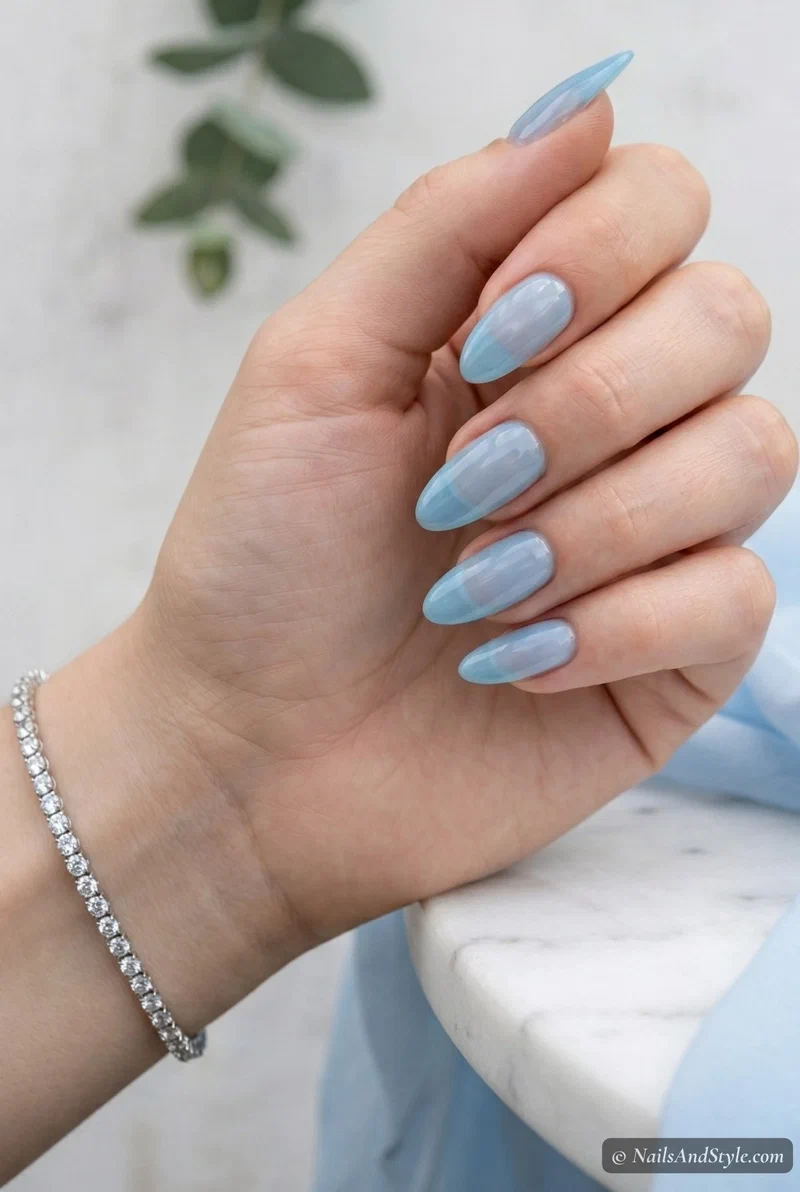 Sheer baby blue jelly nails with translucent finish on medium almond nails