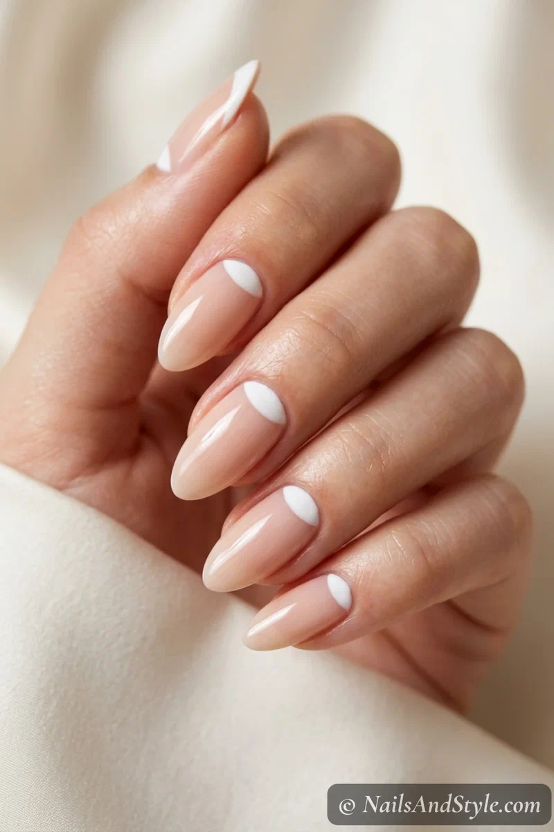Nude nails with white reverse French half-moons